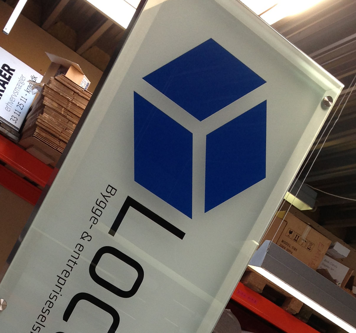 Pylon med Locupleto-logo i glas og metal