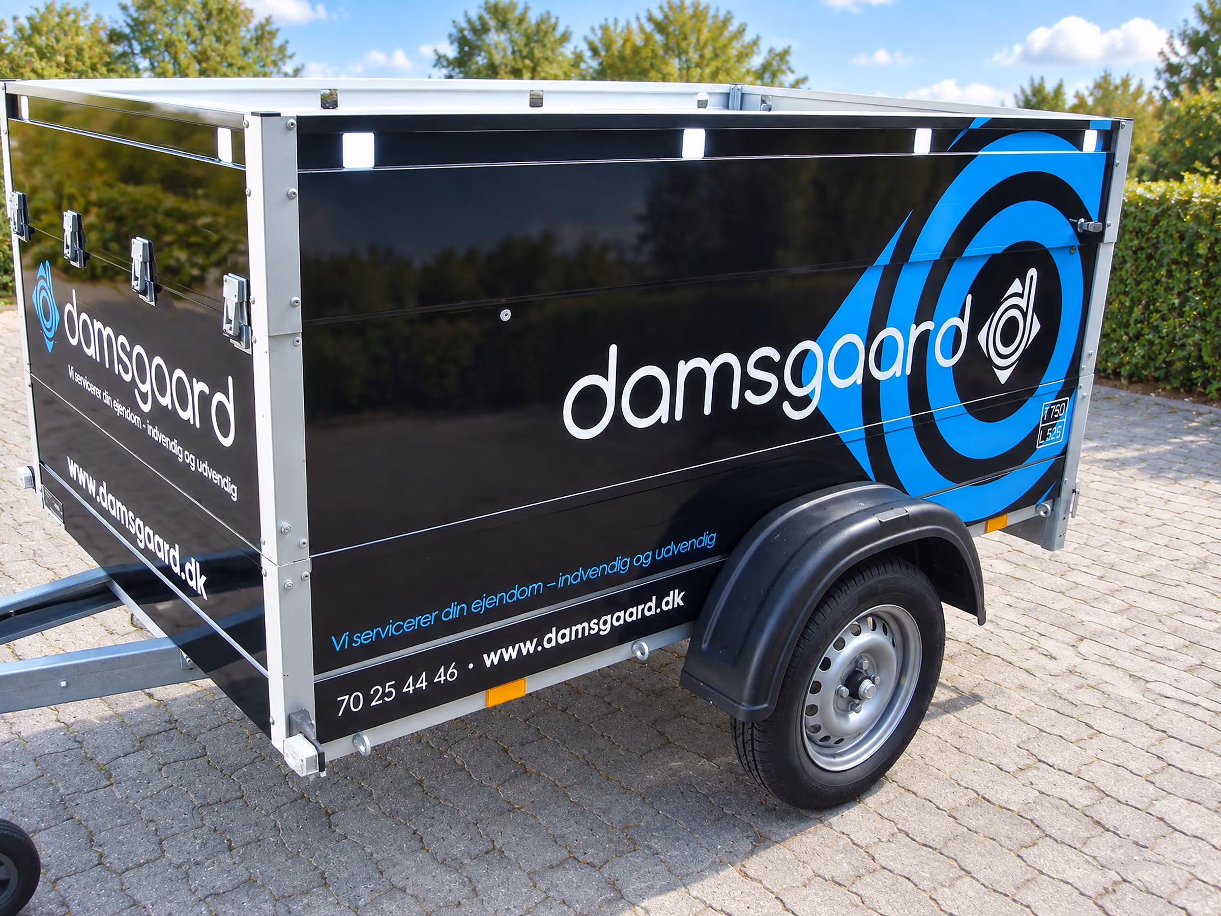 Folie på Damsgaards kassetrailer med logo og blå cirkelgrafik