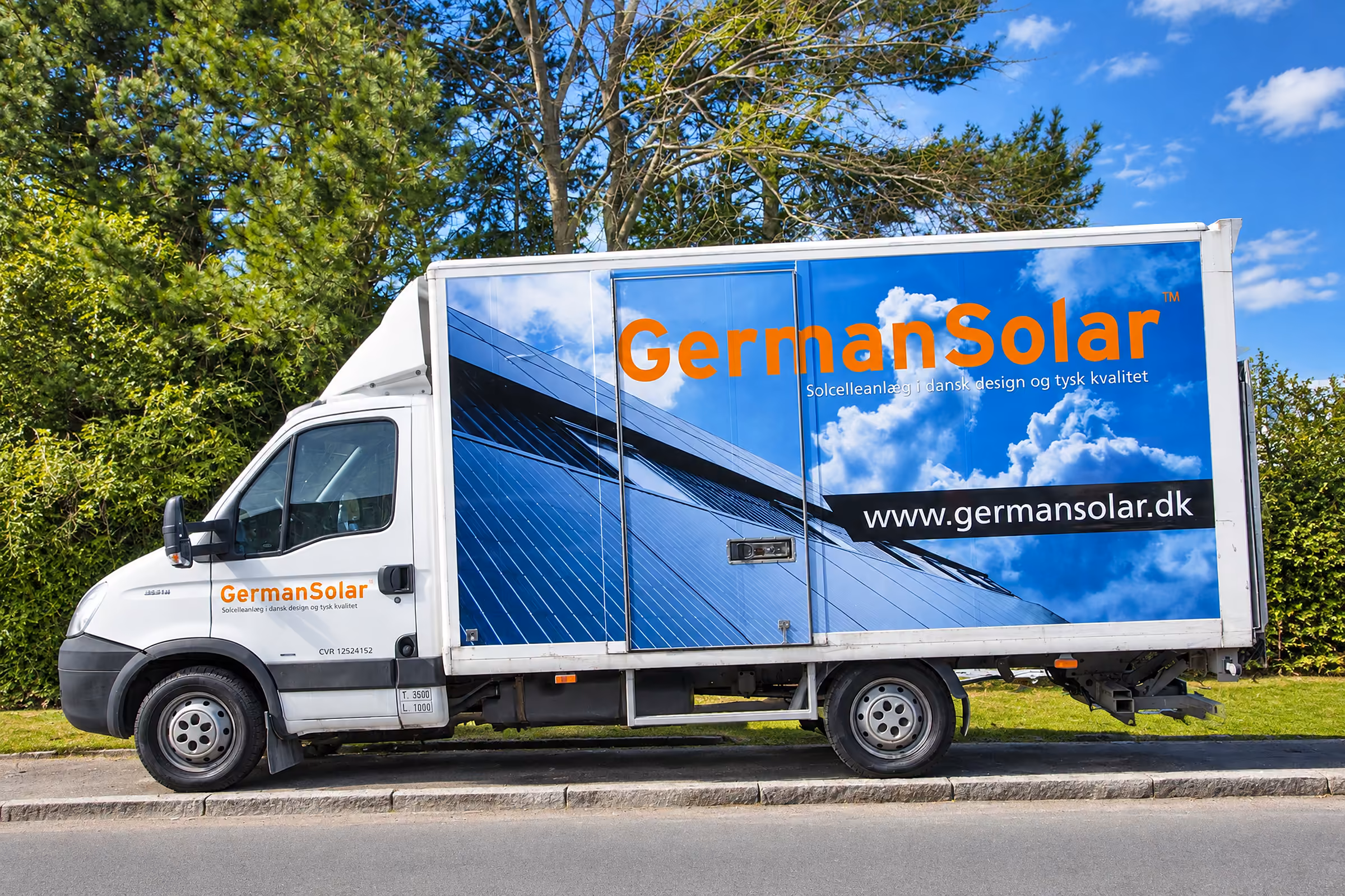 Lastbil med printet kasse til GermanSolar: blå himmel, solceller og logo