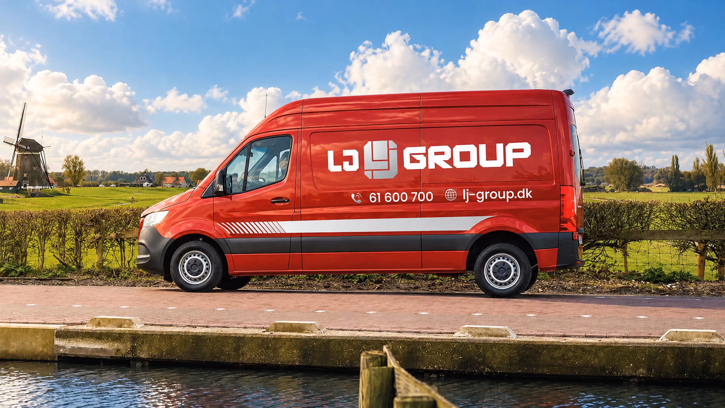 Bilreklame med logo og striber på LJ Groups røde Mercedes Sprinter