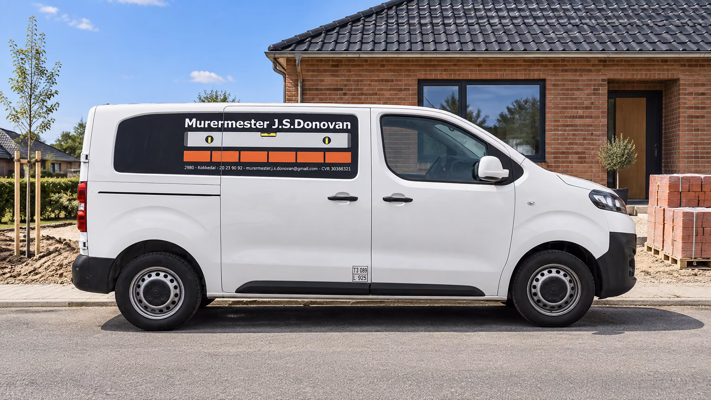 Murermester J.S. Donovans varebil foran et nyt murstenshus