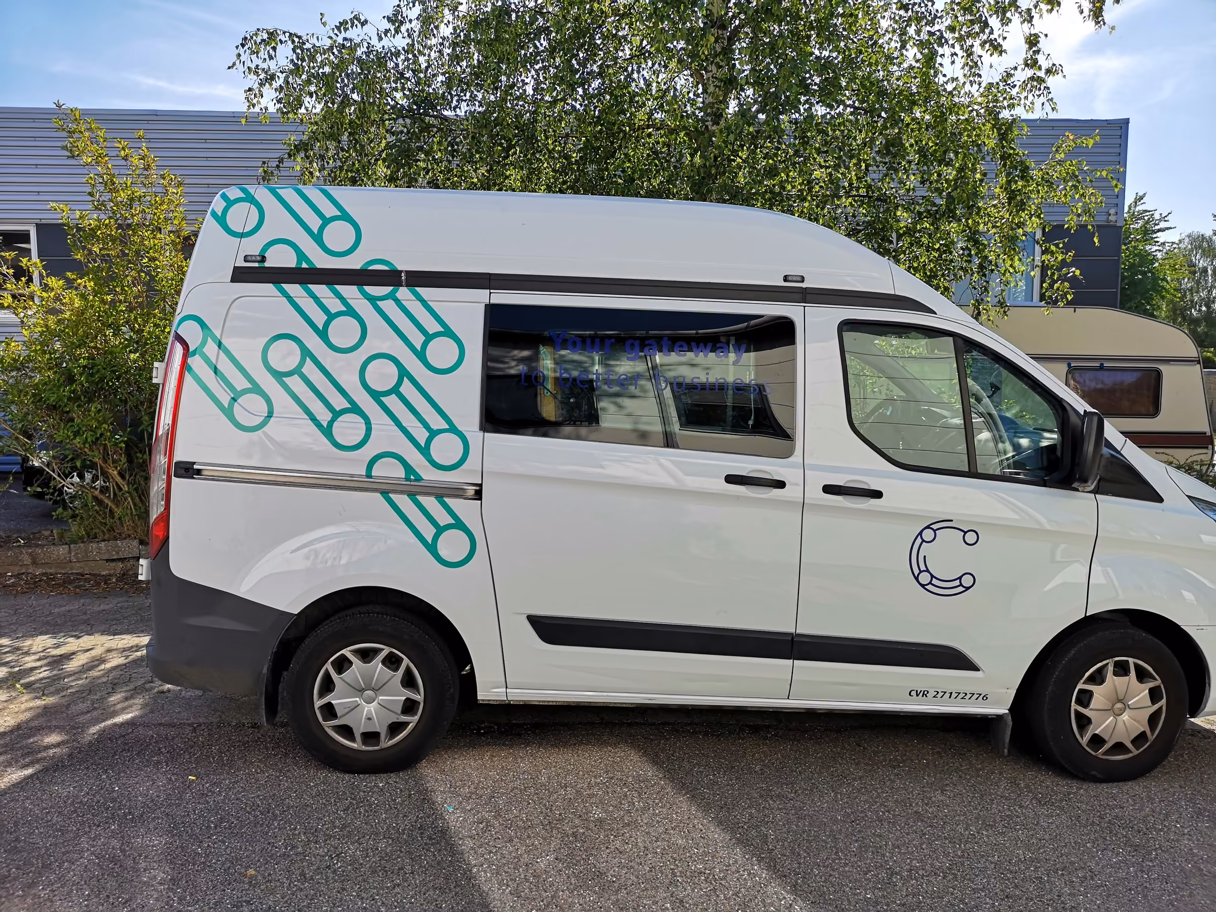 Ford Transit Custom fuldindpakket i hvidt med GlobalConnects logo og mønster