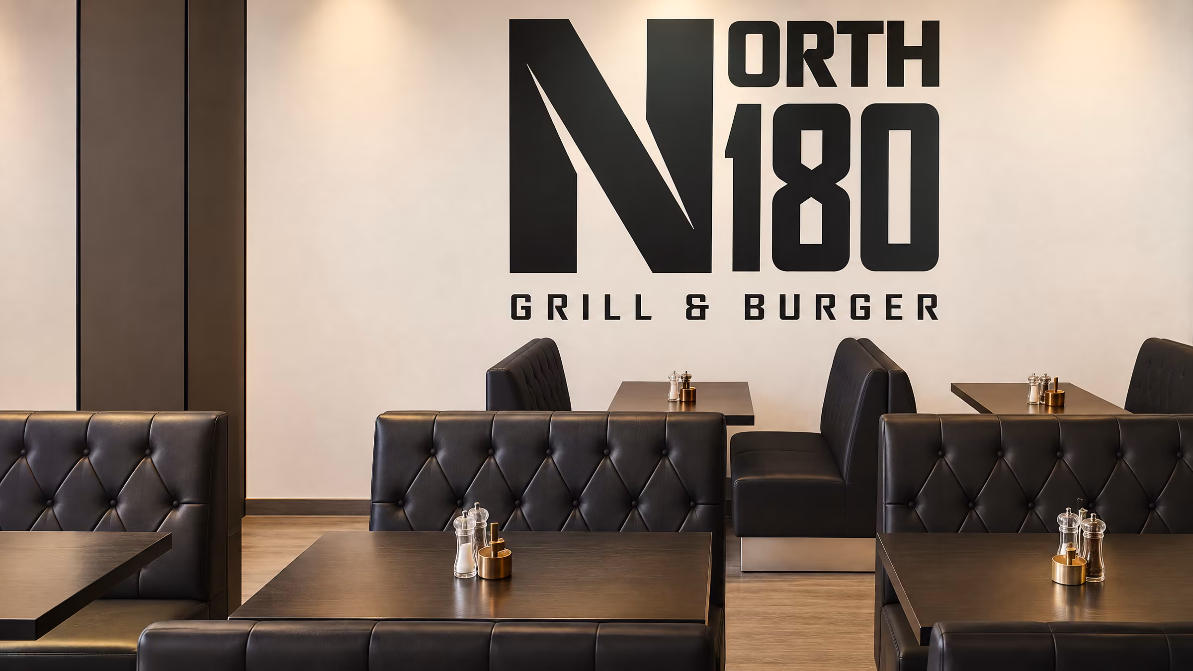 Stort North 180-logo i vægfolie over sofaerne i restauranten