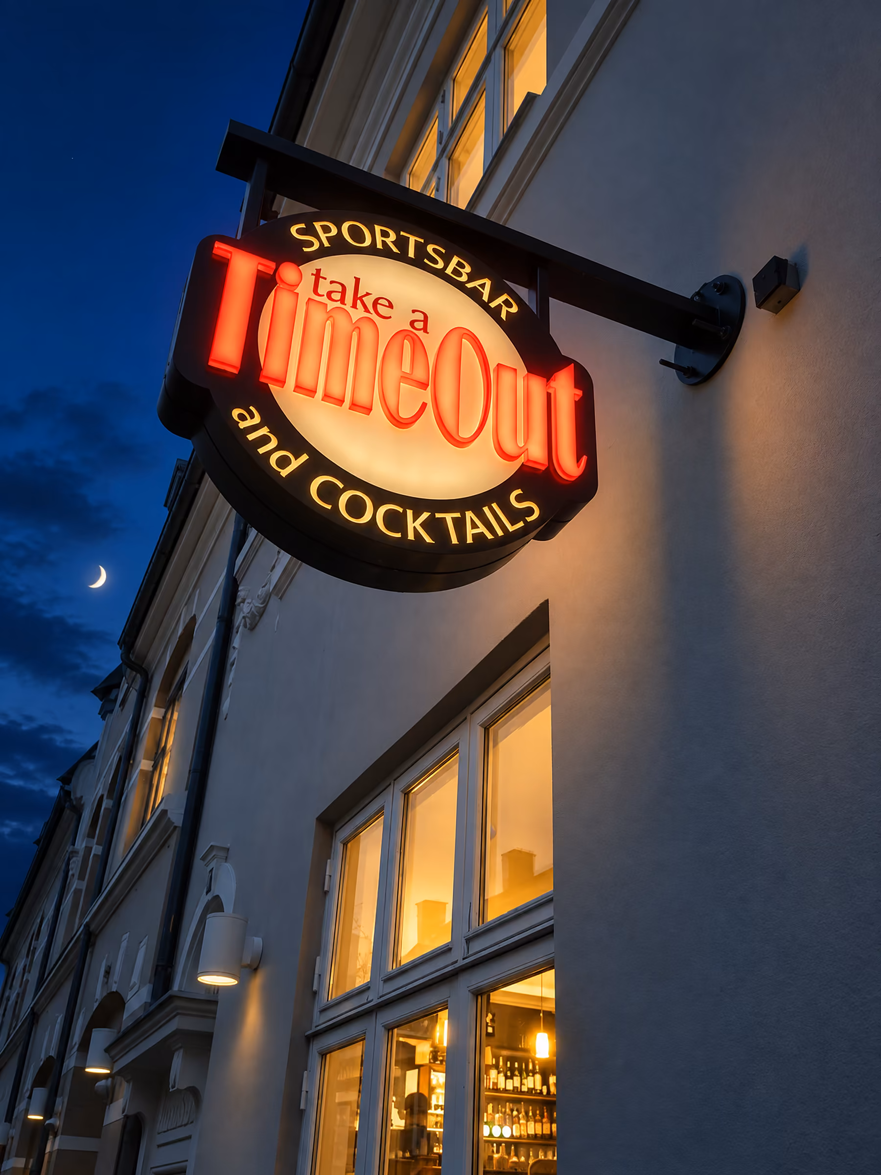 Oplyst udhængsskilt på TimeOut Sportsbar om aftenen